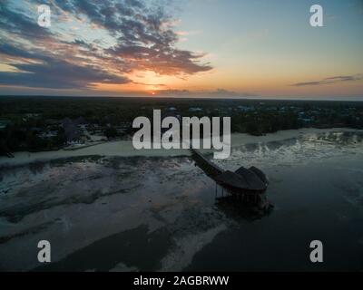 Luftaufnahme eines Piers am Strand am Meer, aufgenommen unter dem Sonnenuntergang in Sansibar, Afrika Stockfoto