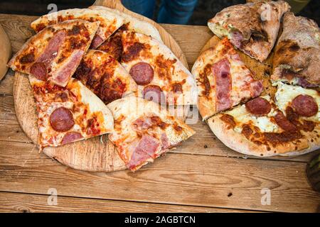 Speck, Salami, Tomate, Käse knusprige Hot pitsa im Verkauf bei einem Anbieter, s Zähler. Stockfoto