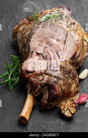 Ganze Lammbraten Bein auf dem schwarzen Stein Hintergrund Stockfoto