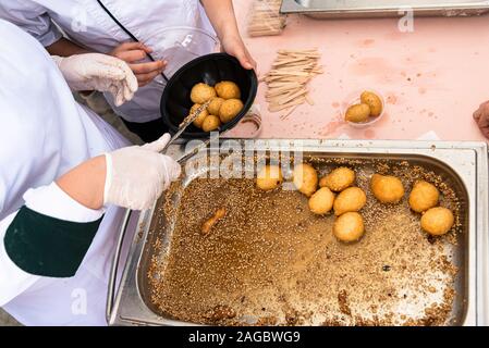 Sweet crispy crunchy Loukoumades berühmten Frittierten griechische traditionelle Gebäck Wüste heiß serviert in Honig getränkt und bestreut mit Zimt und Sesam. Stockfoto