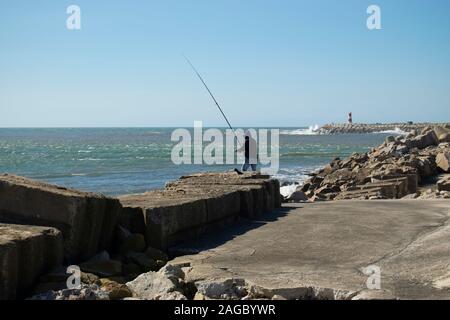 Mann Meer angeln auf dem Causeway am Praia da Barra in der Nähe von Aveiro Portugal Stockfoto