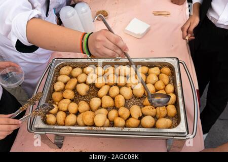 Sweet crispy crunchy Loukoumades berühmten Frittierten griechische traditionelle Gebäck Wüste heiß serviert in Honig getränkt und bestreut mit Zimt und Sesam. Stockfoto