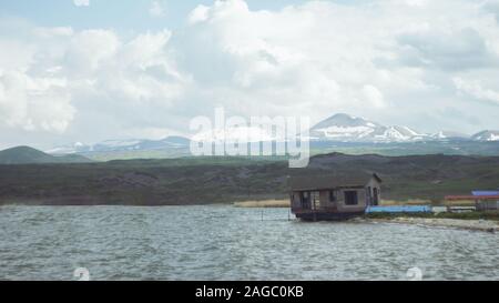 Verlassene alte Hütte in der Nähe des Meeres mit dem schönen Schnee Berge im Hintergrund Stockfoto