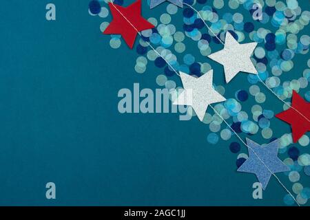 Die Girlande aus bunten Sternen und Konfetti dots auf klassischen blauen Hintergrund. Stockfoto