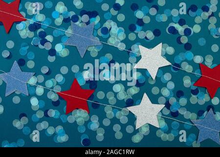 Die Girlande aus bunten Sternen und Konfetti dots auf klassischen blauen Hintergrund. Stockfoto