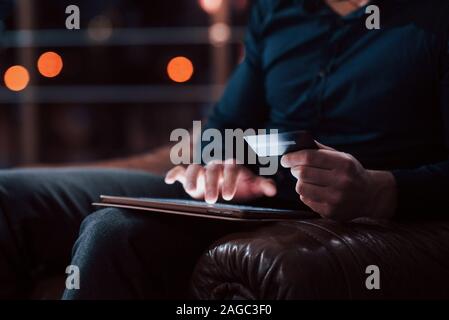 Nahaufnahme der Mann mit Kreditkarte in der Hand, mit Tablet pay Stockfoto