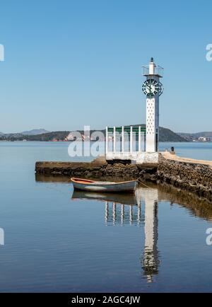 Turm mit Uhr an der Spitze der Stein Pier, kleinen Boot Spiegel Wasser, blauer Himmel, Insel Paqueta, Rio de Janeiro, Brasilien Stockfoto