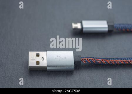 Micro-USB-Kabel mit Kabel vor einem dunklen Hintergrund. Stockfoto