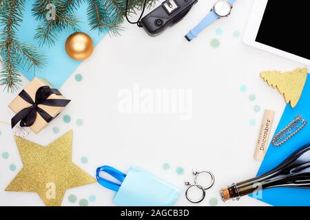 Digitalkamera, Champagner Flasche, Weihnachten Christbaumkugeln, Tanne, Armbanduhr, blau Papier, Holz Block mit Dezember Inschrift, Geschenkbox und Tasche Isola Stockfoto
