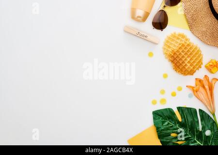 Holzblock mit Juni Inschrift, Sonnenbrille, Stroh, Hut, Waffeln, grünes Blatt, Sonnenschutz, Lily flower Isolated On White Stockfoto