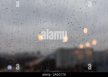 Regentropfen Regen auf dem Fenster, Defokussieren Lantern House schlechtes Wetter. Hintergrund Hintergrund, große Tropfen Wasser auf das Glas Stockfoto