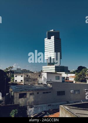 Vertikale Aufnahme eines Stadtbildes mit einem Turmblock darunter Der klare blaue Himmel Stockfoto