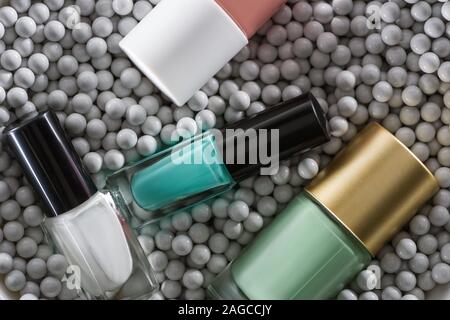 Blick von oben auf die sortierten Nagellack in Flaschen in grau Zierperlen Stockfoto