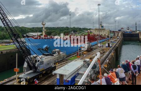 Panama -11/6/19: Ein Blick auf das Schiff Maersk Korsika gehen durch den Panama Kanal, während die Passagiere auf Kreuzfahrtschiffen vom gegenüber Seite der Blick ca Stockfoto