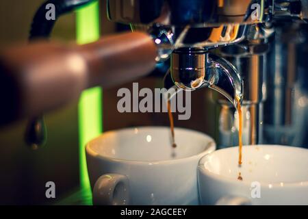 Ein Porträt von der Düse der Kaffeemaschine. Frisch zubereitete und heißem Kaffee wird aus gemahlenen Bohnen. Stockfoto