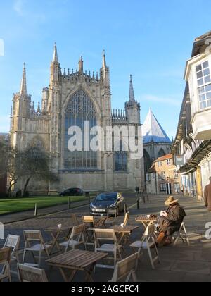 Die grossen Osten Fenster und Fassade des York Minster, gesehen von der Hochschule Straße mit Bürgersteig Tische und Stühle in den Vordergrund. Stockfoto