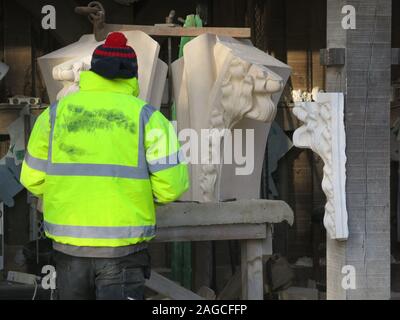 Ein Steinmetz tragen ein hohes-viz Jacke ist bei der Arbeit in der Maurer Hof außerhalb des York Minster meißeln die Felsen, die für Reparaturen und Restaurierung verwendet wird. Stockfoto