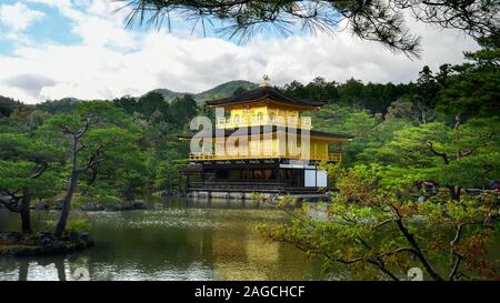 KYOTO, JAPAN - April, 15, 2018: Kinkaku-ji Tempel, der auch als Goldene Pavillon bekannt, von Bäumen eingerahmt Stockfoto