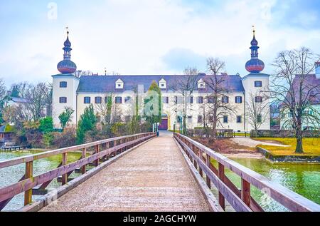 Die schöne mittelalterliche Orth Landschloss Schloss mit zwei Türmen an der Bank der Traunsee mit langen Holzbrücke, Gmunden, Österreich Stockfoto