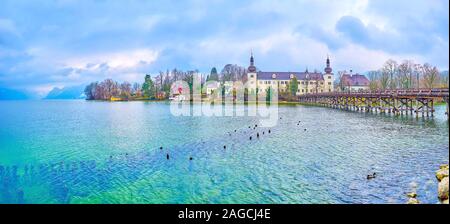 Der malerischen Panoramablick auf Traun See mit mauntains auf dem Hintergrund und mittelalterlichen Orth Landschloss schloss mit alten hölzernen Brücke, Gmunden, Österreich Stockfoto