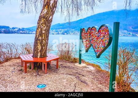 Die beliebten über Jugend die romantische Bank am Rand der Insel in Traun See mit der Skulptur des Herzens, mit bunten Liebe Schlösser eingerichtet, Stockfoto