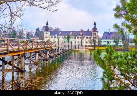 Die langen hölzernen Brücke verbindet das Schloss Schloss Ort auf der kleinen Insel mit Orth Landschloss Schloss am Ufer der Traun See, Gmunden, Österreich Stockfoto