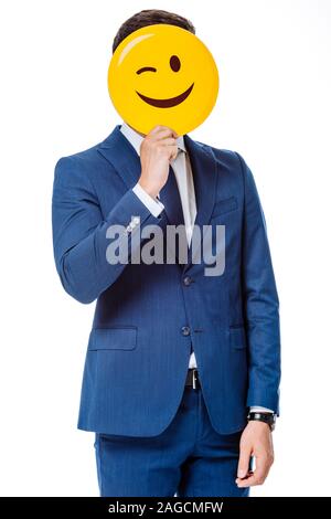 Kiew, Ukraine - 12. AUGUST 2019: Unternehmer im blauen Anzug halten winking Smiley vor Gesicht isoliert auf weißem Stockfoto