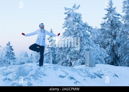 Frau Yoga Posen draußen im Winter im Koli Nationalpark Finnland Stockfoto