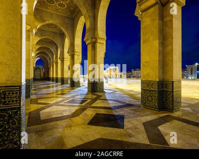 CASABLANCA, MAROKKO - ca. April 2018: Außenkorridor und Bögen der Moschee Hassan II in Casablanca in der Nacht. Stockfoto