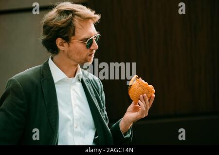 Mann hält einen Burger in der Hand Stockfoto