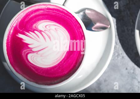 Tasse pink Matcha Latte im Café, in der schönen, sonnigen Tag, Schatten auf dem Tisch Stockfoto