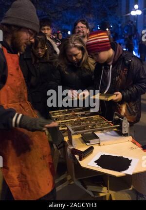 Teilnehmer an der Nuit Blanche Art Festival versuchen ihre Hand am Buchdruck an einem Stand in der Innenstadt von Winnipeg, Manitoba Stockfoto