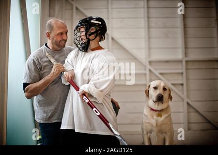 Porträt der jungen Hockeyspieler mit seinem Vati stehend, Stockfoto