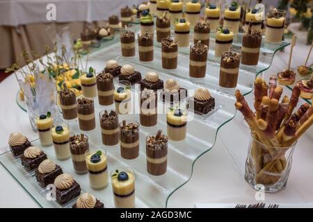 Catering. Off-site Essen. Buffet mit verschiedenen Süße Schokolade Häppchen, Sandwiches und Snacks mit Quark, Erdbeeren, Käse und Minze Stockfoto