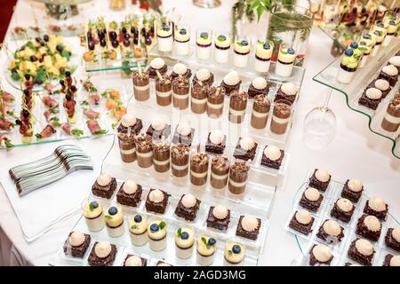 Catering. Off-site Essen. Buffet mit verschiedenen Süße Schokolade Häppchen, Sandwiches und Snacks mit Quark, Erdbeeren, Käse und Minze Stockfoto