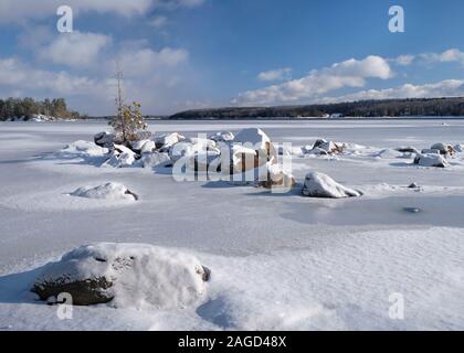 Ein winter Szene der große Schnee Granitblöcke, die das Eis umgeben, wie es in der unteren Buckhorn See, im Kawarthas, Ontario. Stockfoto