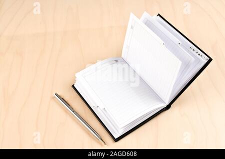 Adressbuch und Kugelschreiber auf Holztisch. Stockfoto