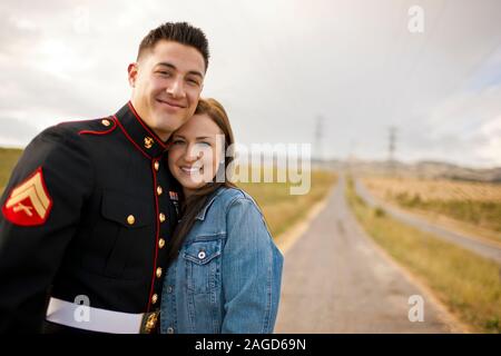 Porträt eines lächelnden jungen Frau, die mit ihrem Partner auf einem ländlichen Landstraße. Stockfoto