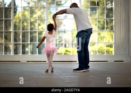 Mitte der erwachsenen Mann hält die Hand seiner jungen Tochter. Stockfoto