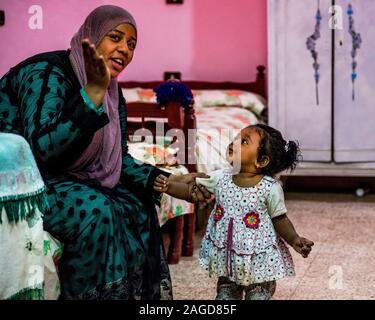 November 2019, ÄGYPTEN - Nubisches Dorf zeigt moslemische Mutter und Kind in der Tür entlang Nil, Ägypten Stockfoto