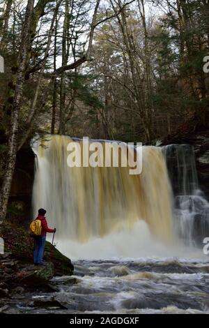 Weibliche Wanderer bewundert, wunderschöne Wasserfälle Stockfoto