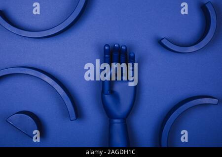 Blaue hand mit abstrakten 3D-Formen. Konzept der Nachweis für die Farbe des Jahres. Stockfoto