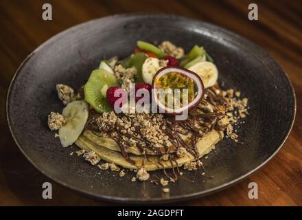 Leckeres Frühstück mit Pfannkuchen und exotischen Früchten Stockfoto