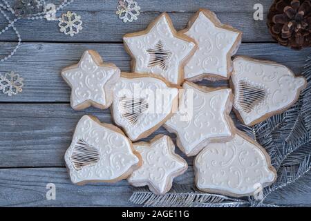 Weihnachten schneiden Sie Cookies in Royal Sahnehäubchen auf hölzernen Tisch dekoriert Stockfoto