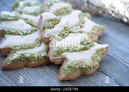 Weihnachten, Baum schneiden Sie Cookies in Royal Sahnehäubchen auf hölzernen Tisch dekoriert Stockfoto