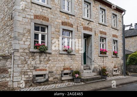 Breinig-Stolberg, Deutschland - Sept. 08, 2019: Seitenansicht von Vorne an einem traditionellen Bauernhaus mit rosa und weißen Blüten auf die Fensterbänke, gebaut Stockfoto