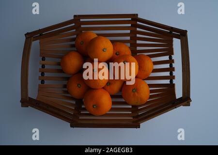 High-Angle Schuss von frischen Mandarinen auf einem Holztablett Mit grauem Hintergrund Stockfoto