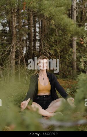 Frau praktizieren Yoga im Wald Stockfoto