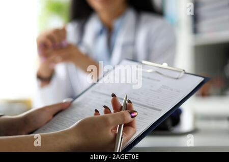 Weibliche Besucher ausfüllen Medizin Dokumente Stockfoto