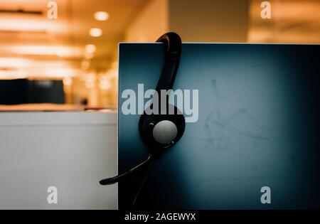Headset sitzt auf einem Computer an einem Schreibtisch in einem Büro Stockfoto